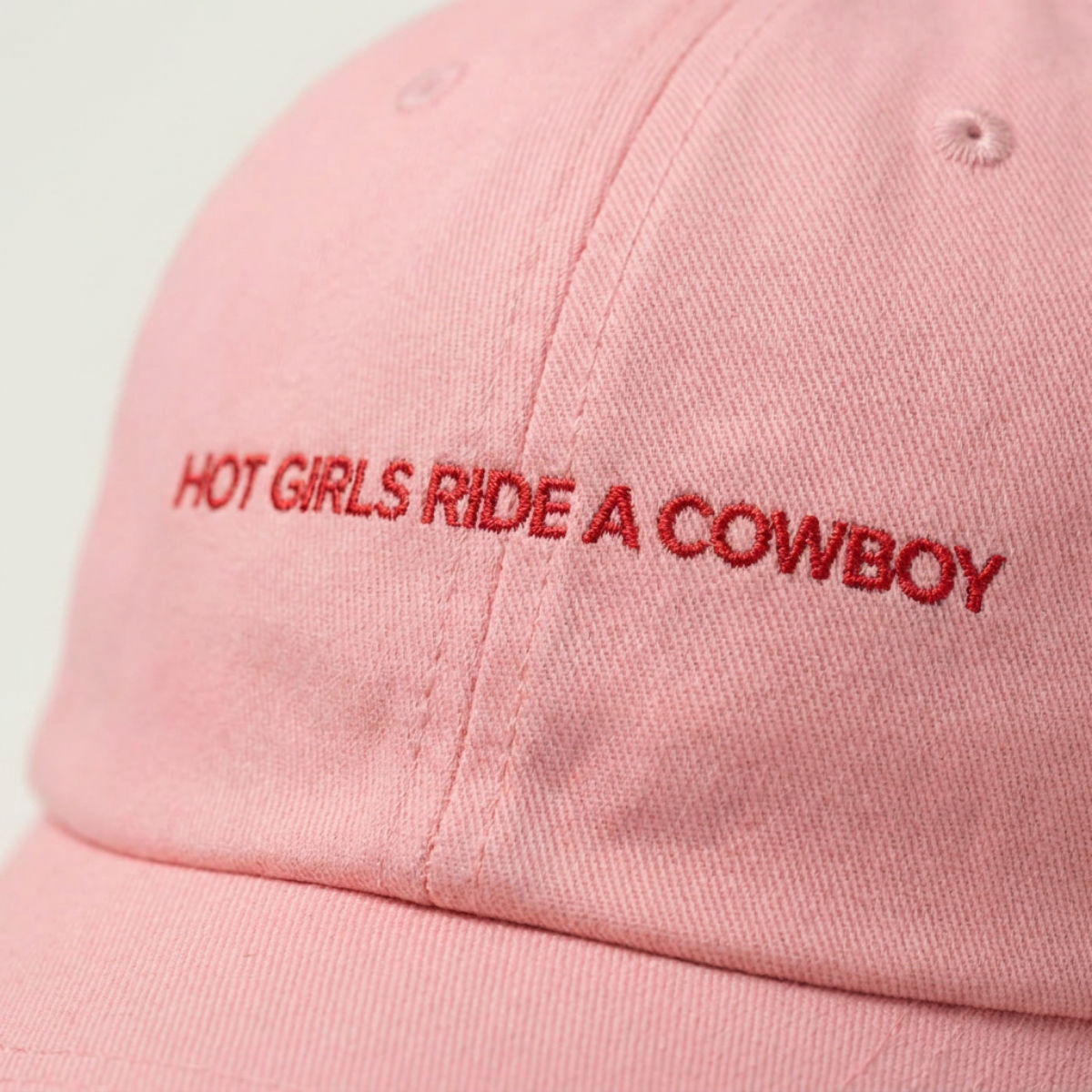 Close-up of the Hot Girls Ride a Cowboy embroidery on a dad cap