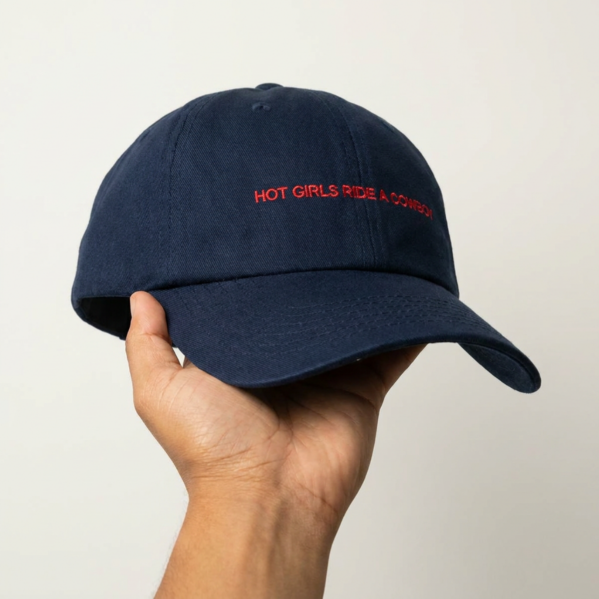Hot Girls Ride a Cowboy embroidered dad cap held in hand