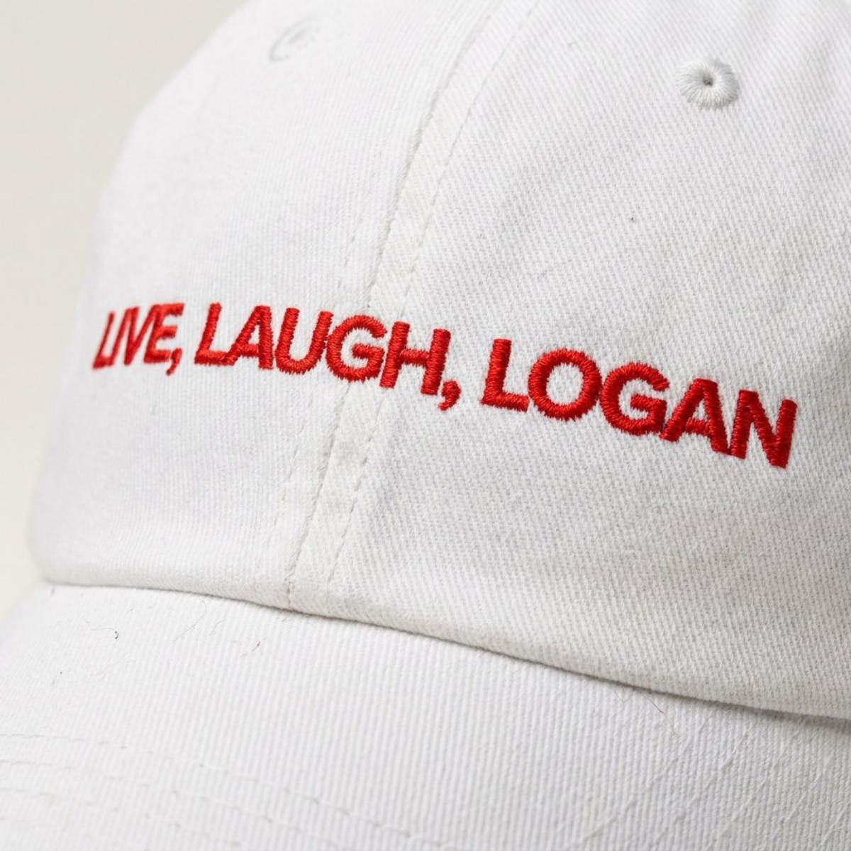 Close-up of the Live, Laugh, Logan embroidered slogan on a dad cap